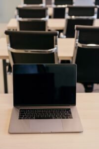 An empty conference room setup with a laptop on a desk, ready for a seminar.